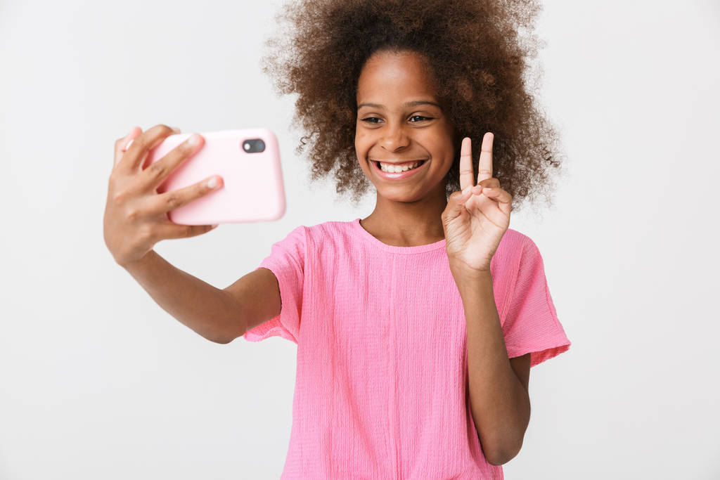 Heureux jeune fille africaine enfant en utilisant le téléphone mobile
. - Photo, image