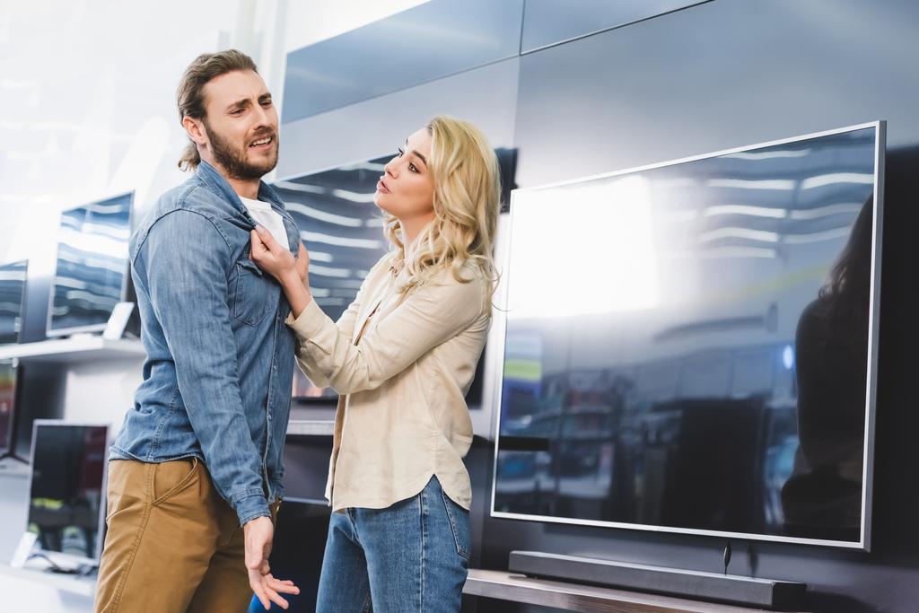 tyttöystävä kysyy surullinen poikaystävä lähellä televisiota kodinkone myymälä
  - Valokuva, kuva