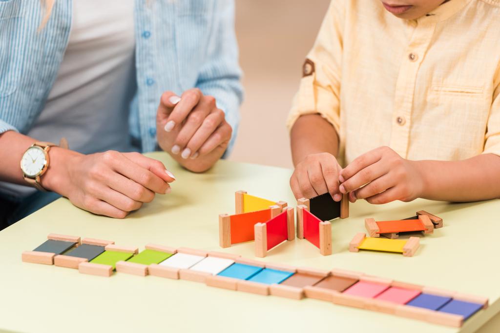 Vágott nézet a gyerek és a tanár játszik oktatási játék az asztalnál során lecke Montessori osztály - Fotó, kép