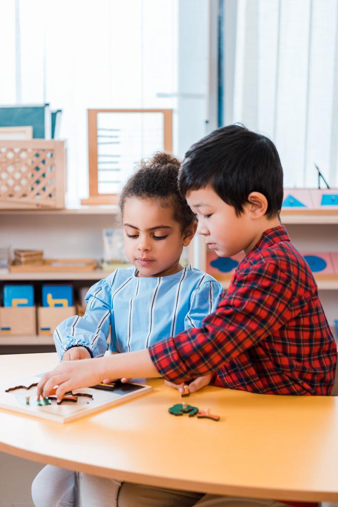 Děti hrající vzdělávací hru u stolu ve třídě montessori - Fotografie, Obrázek