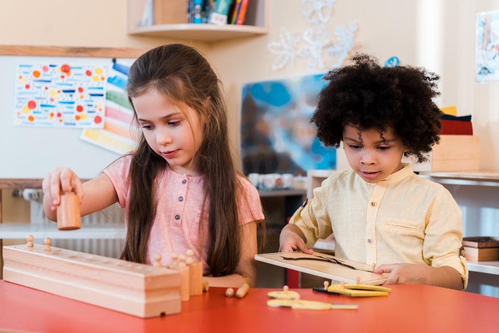 Valikoiva painopiste lasten pelaa puisia pelejä oppitunnin aikana Montessori koulussa
 - Valokuva, kuva