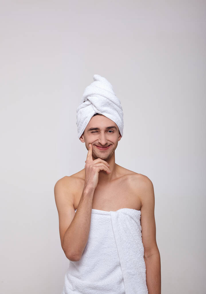 Duştan sonra genç bir beyaz adam göz kırpıyor ve gülümsüyor.. - Fotoğraf, Görsel