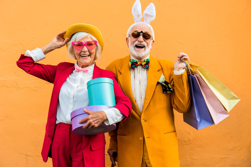 Szczęśliwa para starców w kolorowe kostiumy pozowanie z prezentami - Zdjęcie, obraz