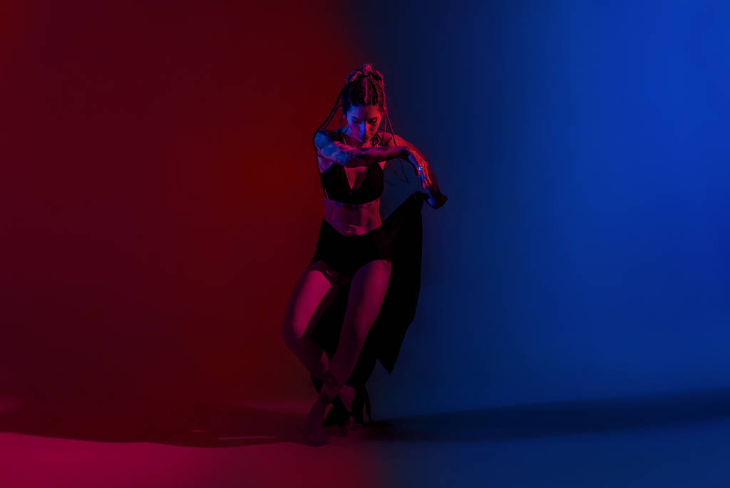 黒服と編組髪の女性ダンス上の青と赤b - 写真・画像