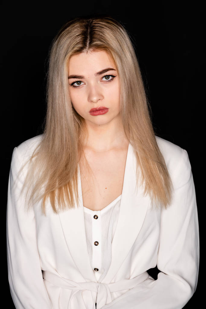 close-up portret van mooi jong model met blond haar en zwarte kleren, poseren in fotostudio op donkere achtergrond - Foto, afbeelding