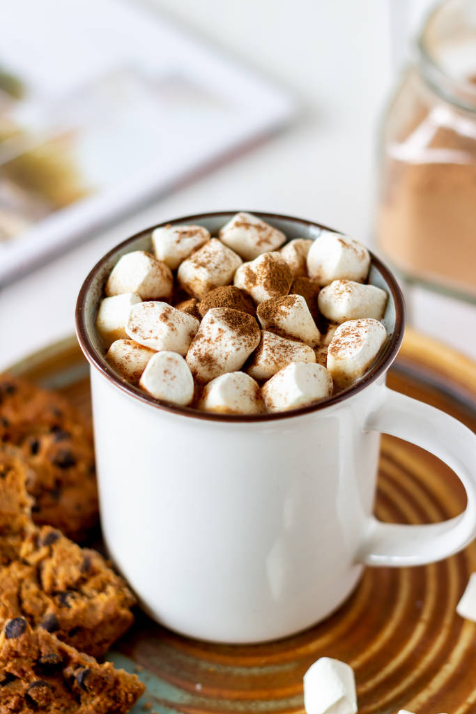 Chocolat chaud avec guimauves dans une tasse blanche sur un fond blanc. Recettes
. - Photo, image