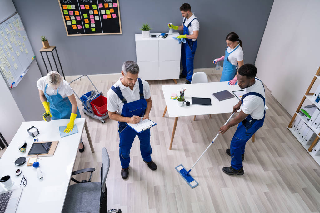 conciërge met zijn team schoonmaken van modern kantoor - Foto, afbeelding