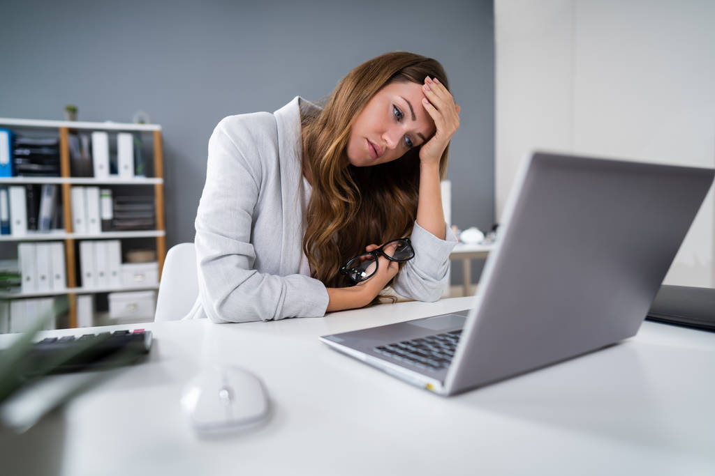 Triste giovane donna che lavora sul computer portatile alla scrivania
 - Foto, immagini