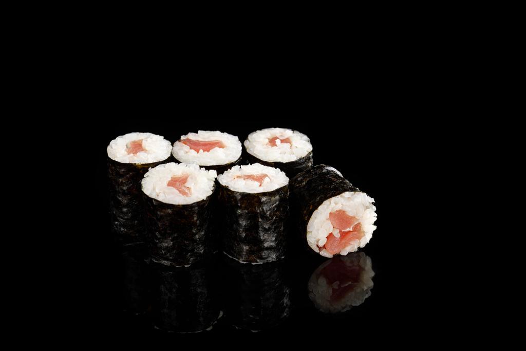 マグロを黒で孤立させたおいしい寿司巻き - 写真・画像