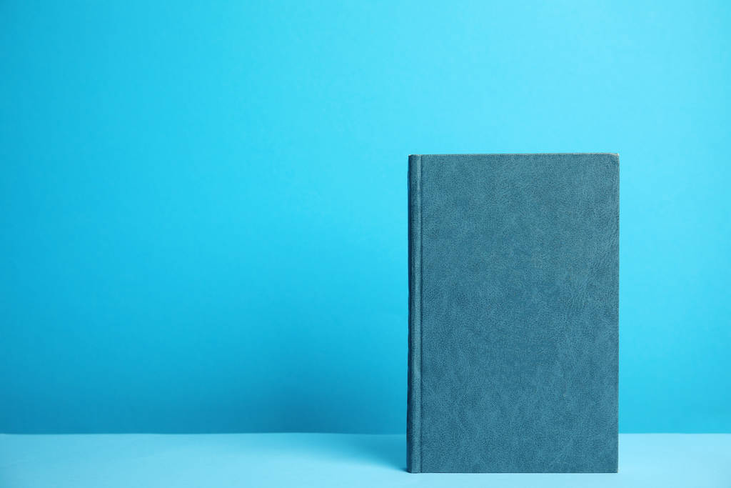 Книга в твердом переплете на голубом фоне. Пространство для дизайна
 - Фото, изображение