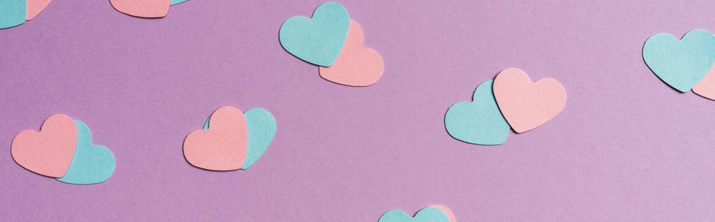 бесшовный рисунок цветных бумажных сердец на фиолетовом фоне, панорамный снимок
 - Фото, изображение