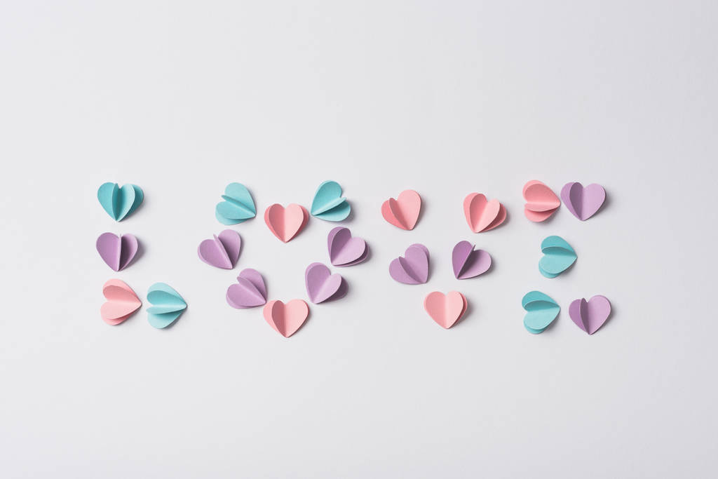 Beyaz arka planda renkli kağıt kalplerden yapılmış aşk harflerinin üst görünümü - Fotoğraf, Görsel