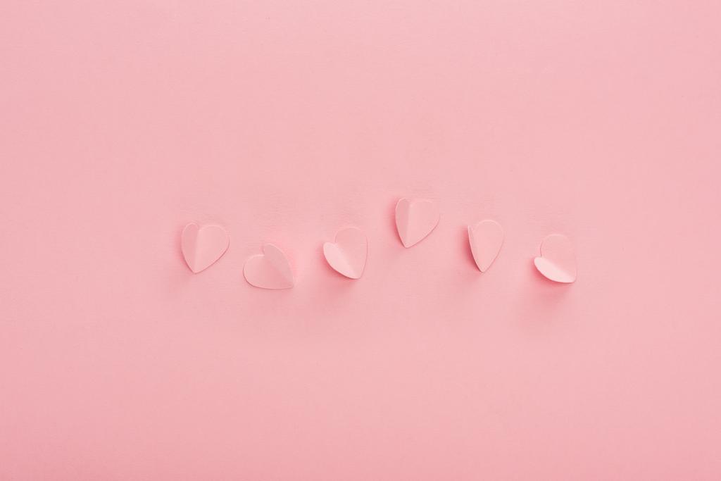 felső nézet rózsaszín papír szív rózsaszín háttér - Fotó, kép