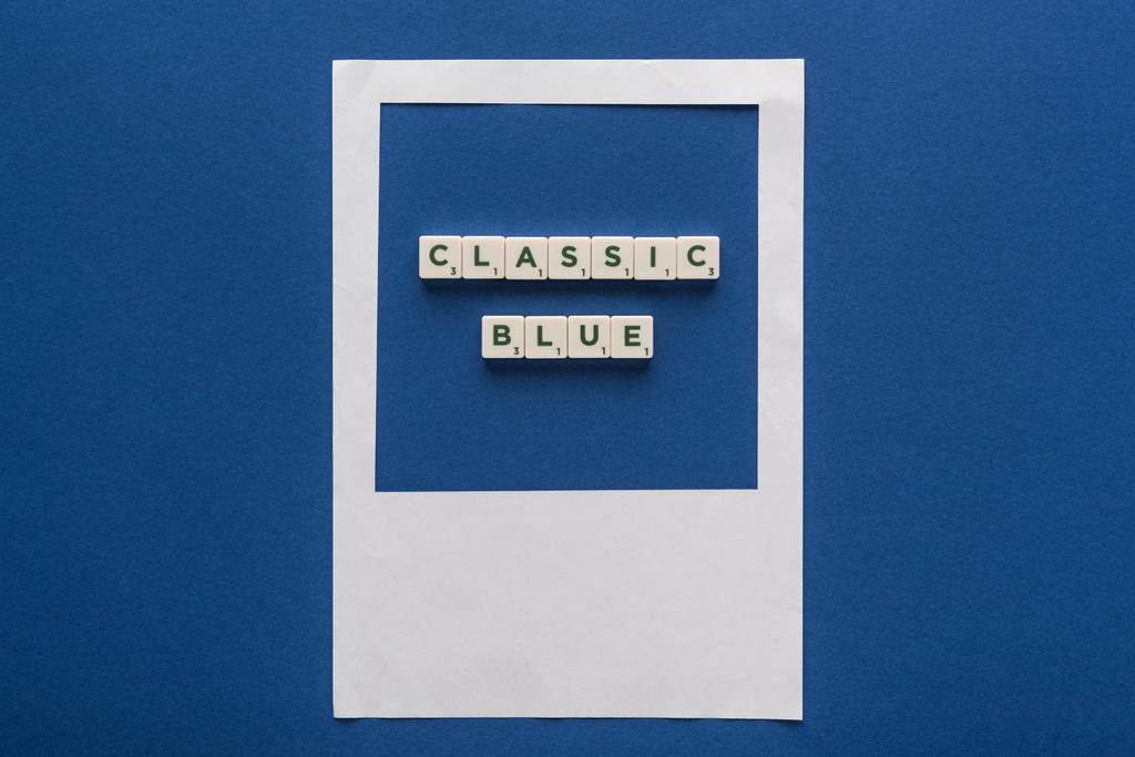 青い背景の白い写真フレームのキューブに古典的な青い文字のトップビュー - 写真・画像