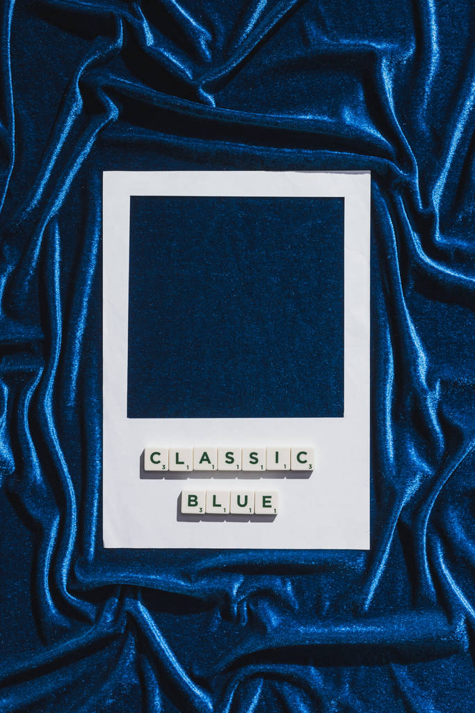 青いベロアの布の上のキューブと白い写真フレームの古典的な青のレタリングのトップビュー - 写真・画像