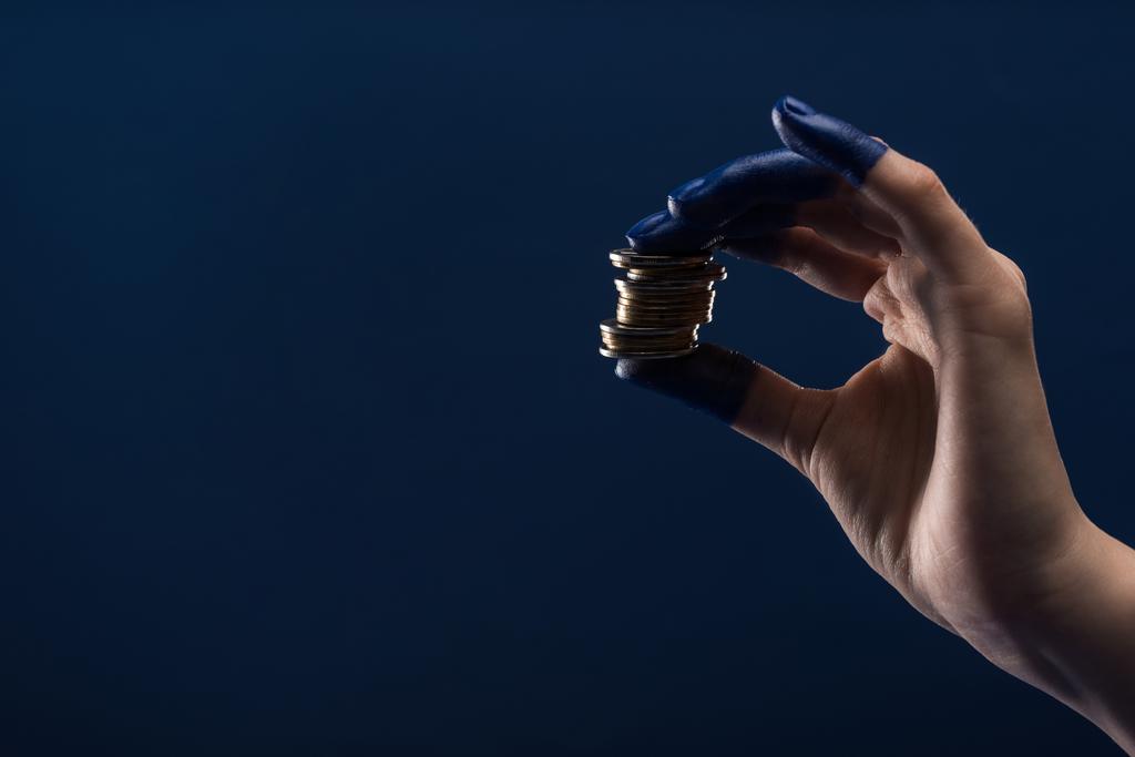 vista ritagliata della mano femminile con le dita dipinte in possesso di monete isolate su blu
 - Foto, immagini