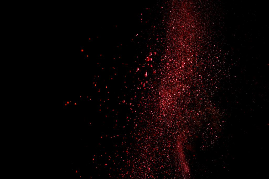 rood kleurrijke holi verf explosie op zwarte achtergrond - Foto, afbeelding