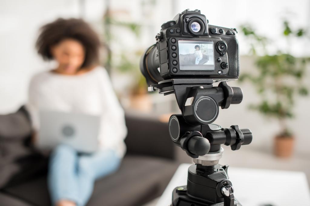 valikoiva painopiste digitaalikamera nuorten afrikkalainen amerikkalainen video bloggaaja käyttäen kannettavaa tietokonetta esillä
  - Valokuva, kuva