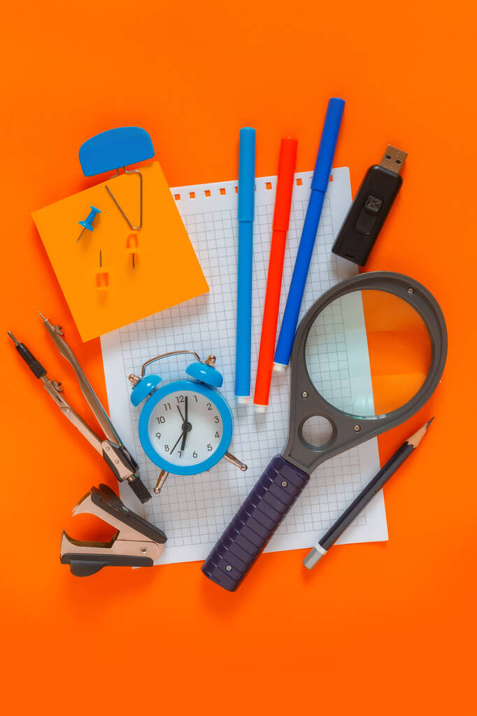 Vissza a suliba. Modernizált design minta iskolai kellékek ceruzák, filctollak, ébresztőóra, notebook másolás hely, iskolai modell poszter egy narancssárga korall tábla háttér  - Fotó, kép