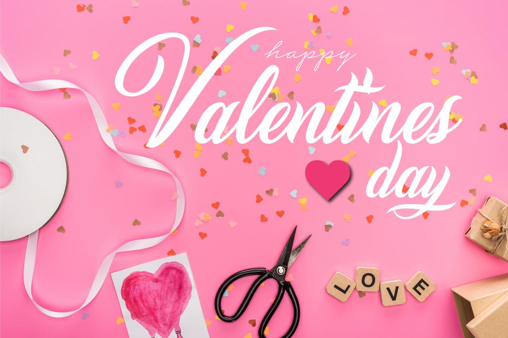 bovenaanzicht van valentijnskaarten confetti, lege compact disk, schaar, geschenkdozen, wenskaart en liefdesbelettering op houten blokjes op roze achtergrond met vrolijke Valentijnsdag illustratie - Foto, afbeelding