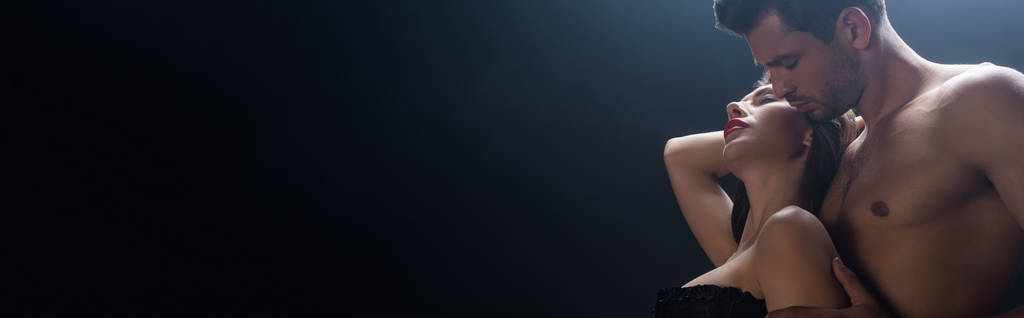 Panoráma felvétel félmeztelen férfi átöleli szexi nő elszigetelt fekete  - Fotó, kép