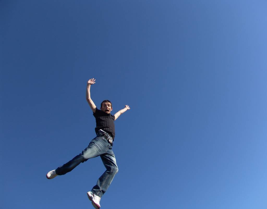 jonge man springt tegen de blauwe lucht - Foto, afbeelding