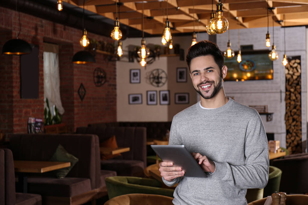 Young business owner with tablet in his cafe. Space for text - Photo, Image