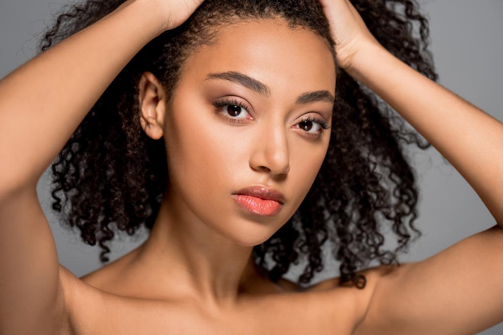 portrét atraktivní africké americké dívky s kudrnatými vlasy, izolované na šedi - Fotografie, Obrázek