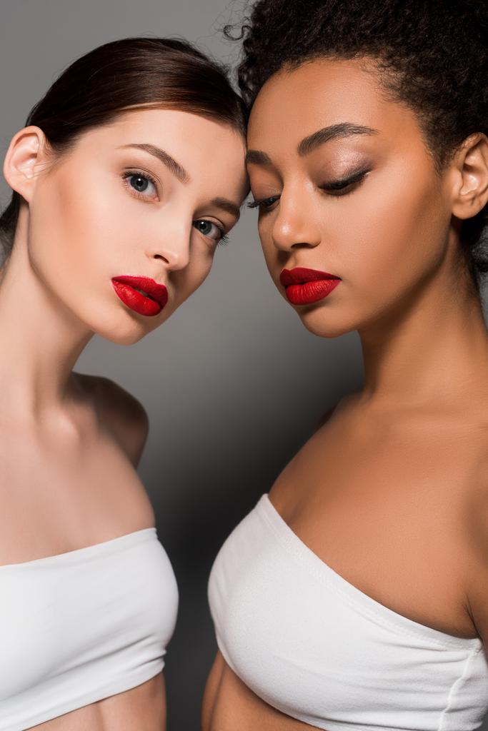 ελκυστικές πολυπολιτισμικές νεαρές γυναίκες με κόκκινα χείλη, σε γκρι  - Φωτογραφία, εικόνα