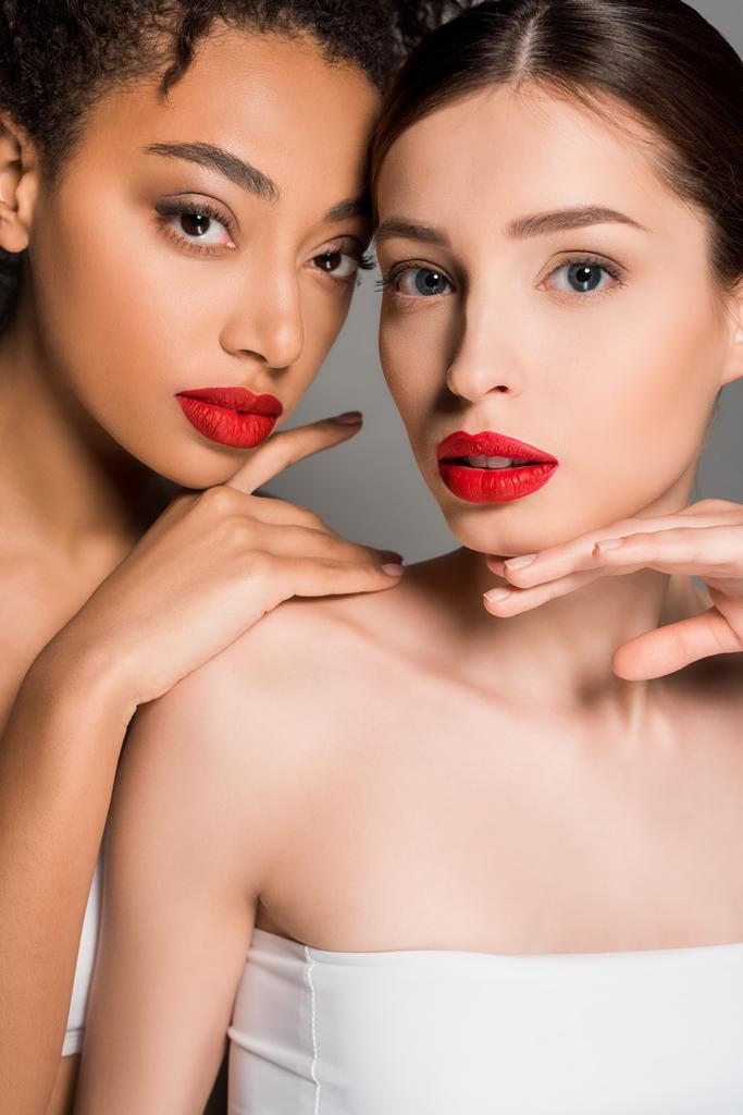 gyönyörű multietnikus fiatal nők piros ajkak, elszigetelt szürke  - Fotó, kép