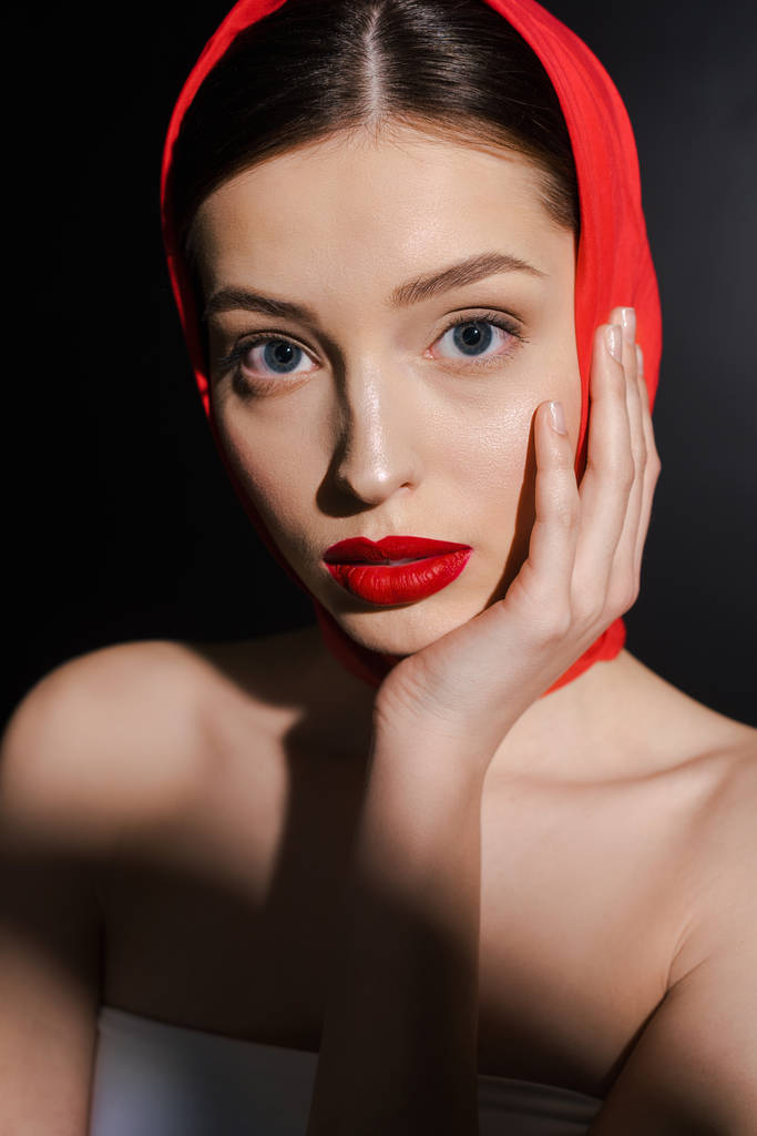 ελκυστική νεαρή γυναίκα με κόκκινο μαντήλι, απομονωμένη σε μαύρο - Φωτογραφία, εικόνα