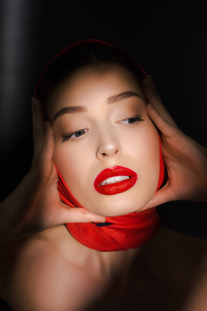 retrato da menina elegante bonita na moda com cachecol vermelho, isolado em preto
 - Foto, Imagem