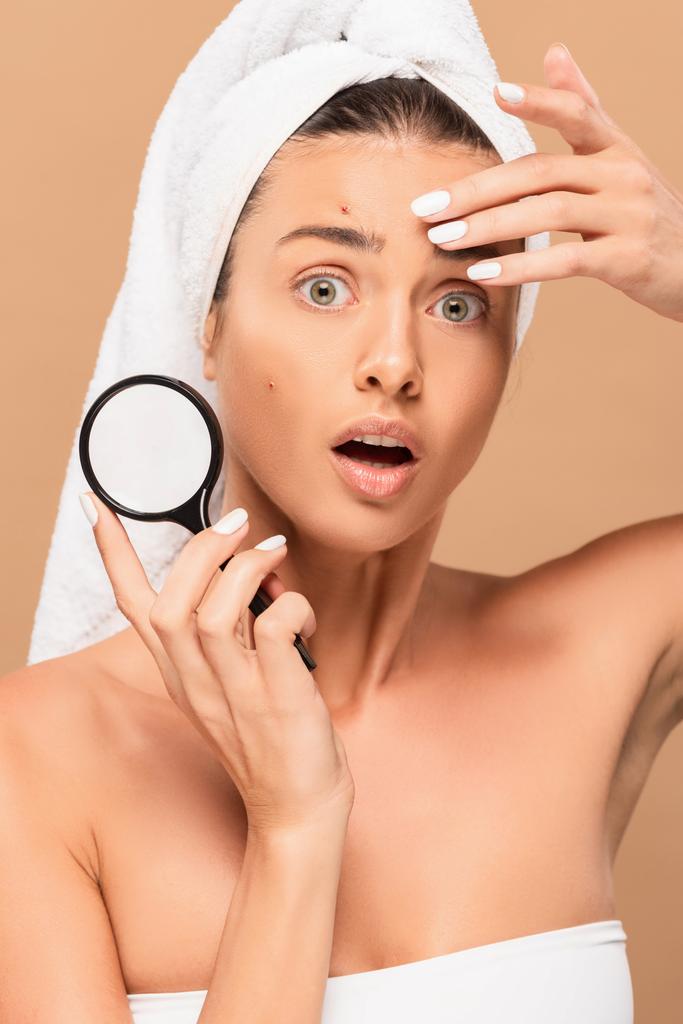 surprised young woman with pimples on face holding magnifier isolated on beige  - Photo, Image