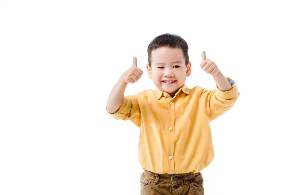 幸せなアジア系の少年が白で孤立した親指を見せ - 写真・画像