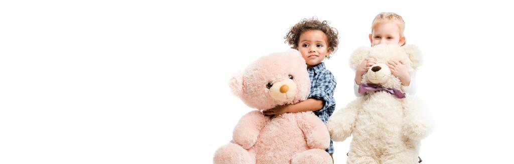 panoramic shot of adorable multiethnic children holding teddy bears,  isolated on white  - Photo, Image