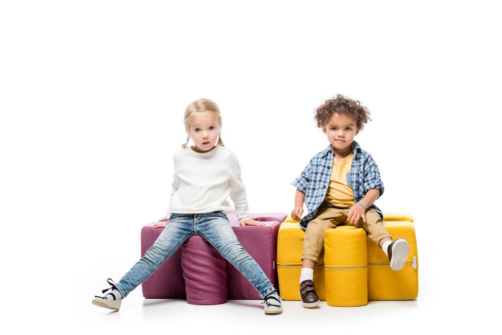 Lustige multikulturelle Kinder sitzen auf Puzzlestühlen, auf weißen - Foto, Bild