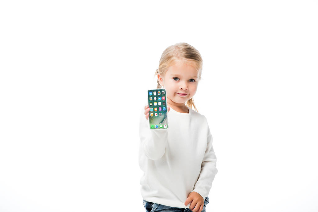 KYIV, UCRANIA - 18 de noviembre de 2019: niño adorable mostrando teléfono inteligente con pantalla de iphone, aislado en blanco
  - Foto, Imagen