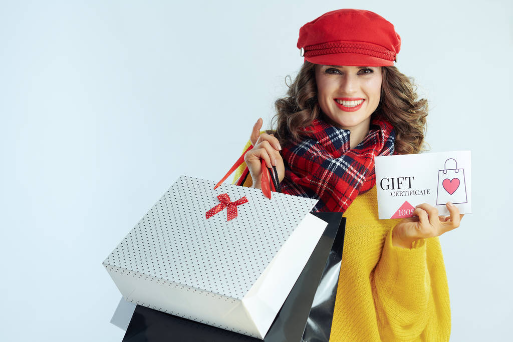 ευτυχισμένη γυναίκα με τσάντες ψώνια που δείχνουν δώρο πιστοποιητικό - Φωτογραφία, εικόνα