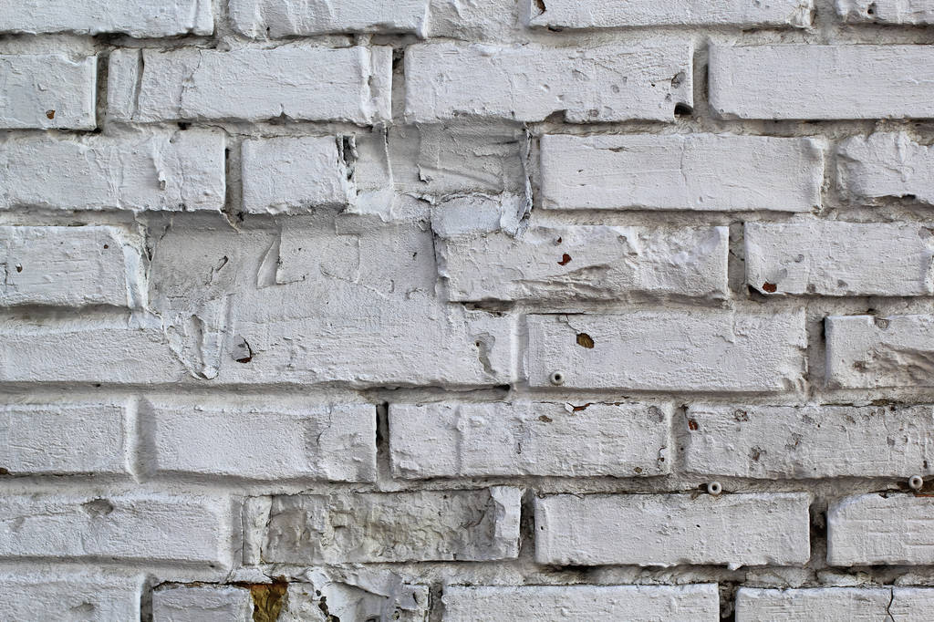 grezzo muro bianco grigiastro con mattoni irregolari e mancanti per lo sfondo
 - Foto, immagini