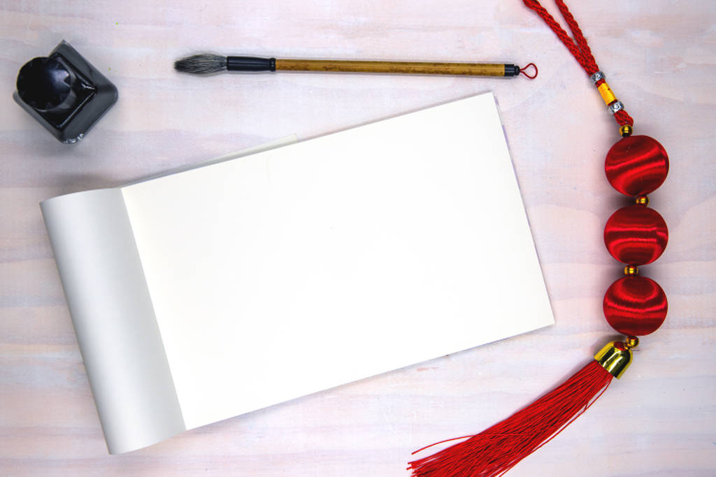 Blank open notebook page and calligraphy supplies. Oriental decoration flat lay on white wooden table. - Foto, immagini