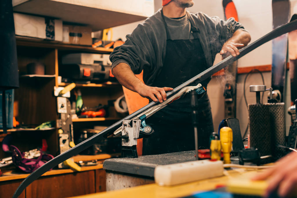 обрізаний вид на працівника, який ремонтує сноуборд у ремонтному магазині
  - Фото, зображення