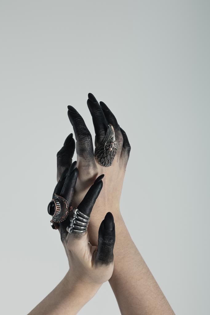 Vágott kilátás boszorkány kezét fekete festék és ékszer gyűrűk elszigetelt szürke  - Fotó, kép