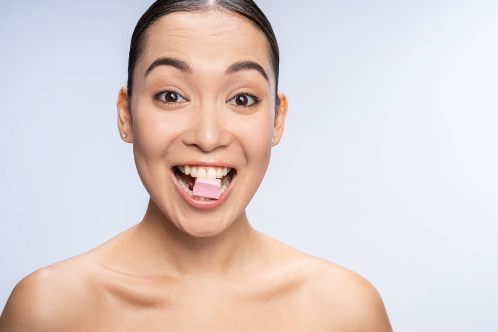 Femme asiatique avec des épaules nues posant pour caméra en studio
 - Photo, image