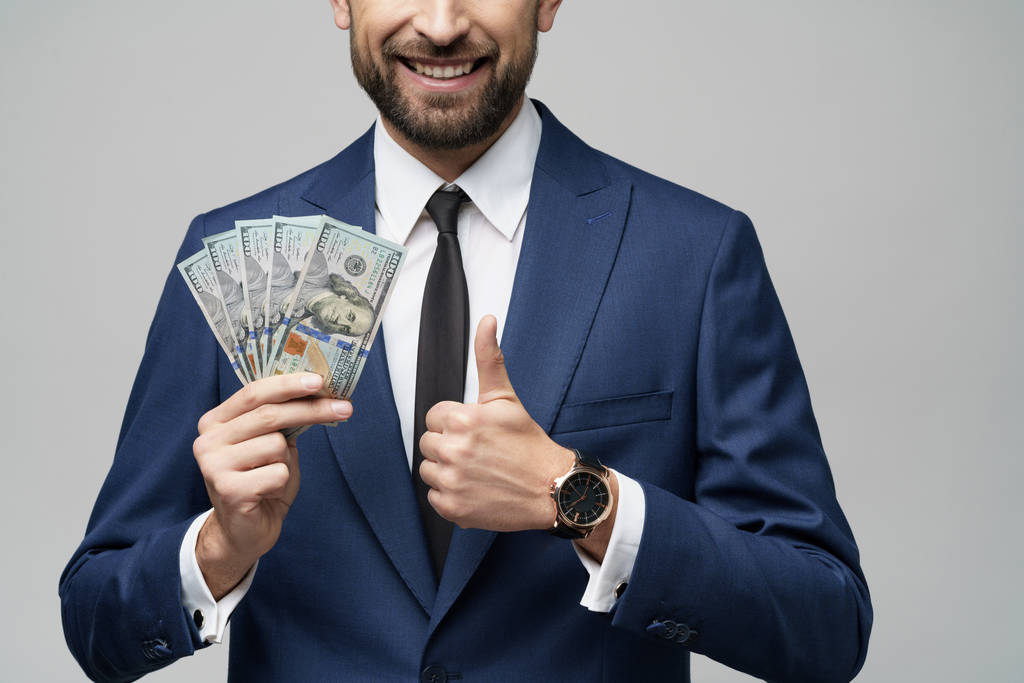 νεαρός όμορφος επιχειρηματίας που κατέχει δολάρια ΗΠΑ χαρτονομίσματα - Φωτογραφία, εικόνα