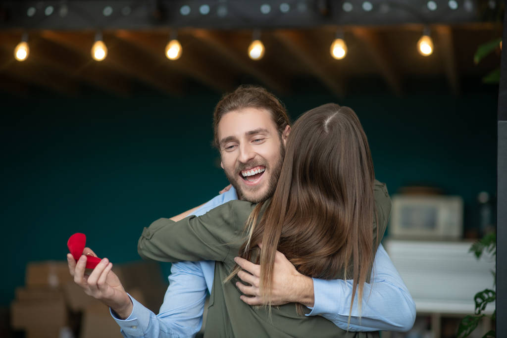 Mulher abraçando um homem sorridente depois de receber uma proposta
 - Foto, Imagem
