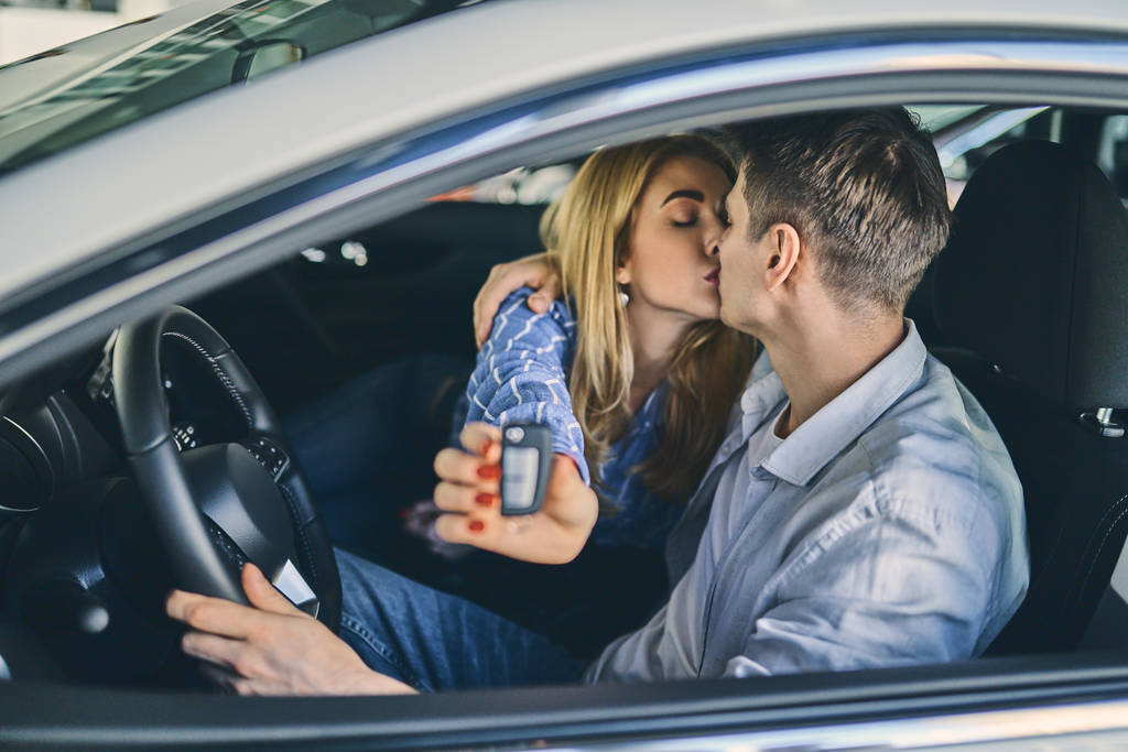 Šťastný pár drží klíč od auta po zakoupení v showroomu. - Fotografie, Obrázek