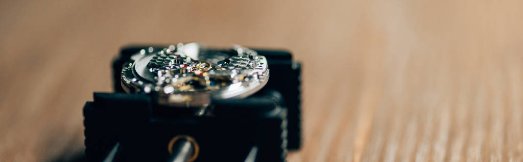 Vue rapprochée de la montre-bracelet mécanique sur support de mouvement sur table en bois, vue panoramique
  - Photo, image