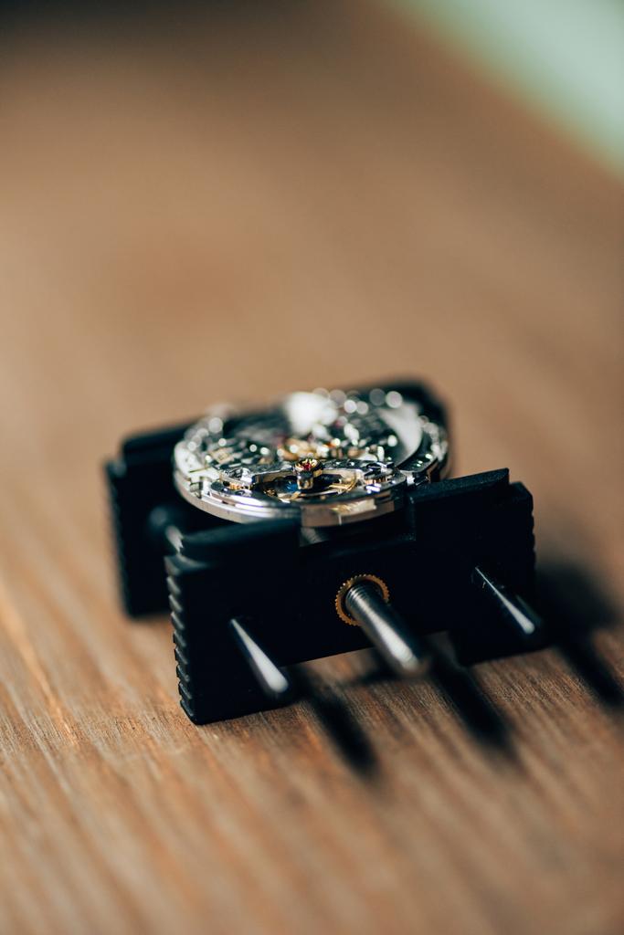 Enfoque selectivo del reloj de pulsera abierto en el soporte de movimiento en la mesa
 - Foto, imagen