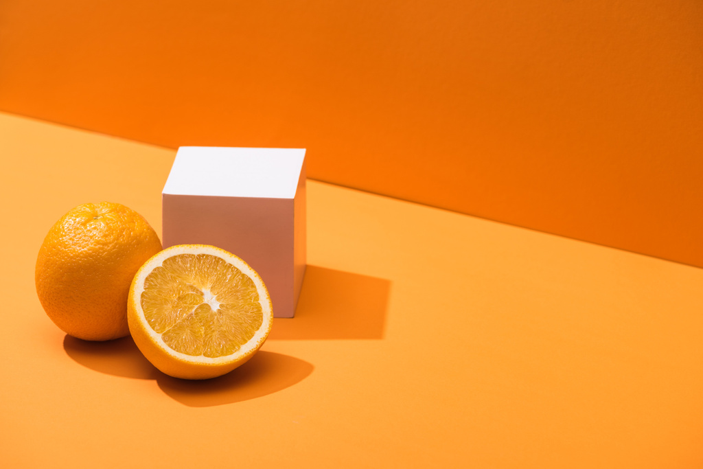 arance fresche e cubo bianco su sfondo arancione
 - Foto, immagini