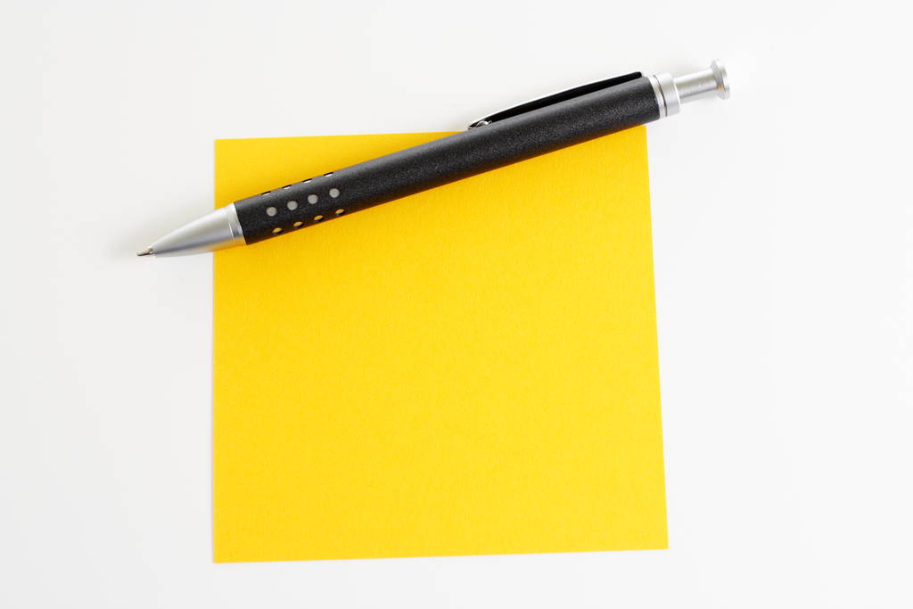 bloc de notas amarillo con pluma - Foto, imagen